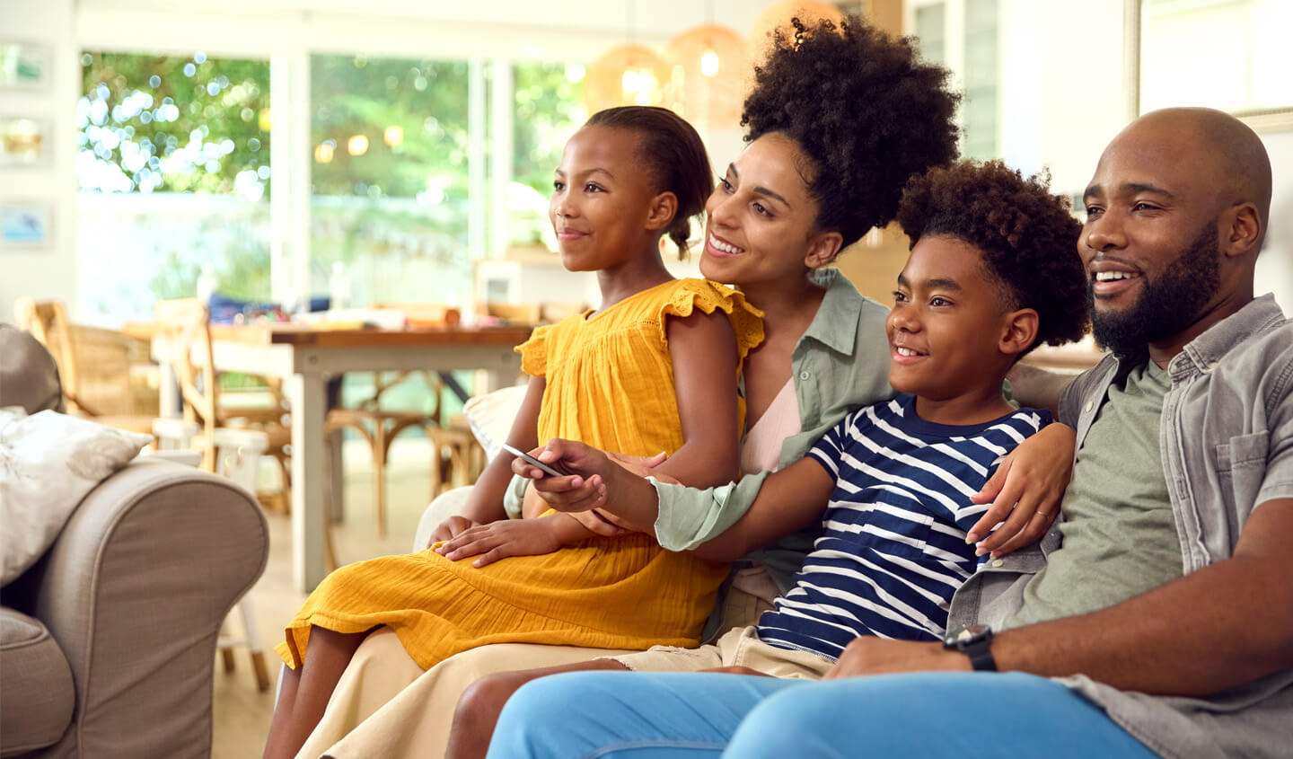 Family in a couch watching television