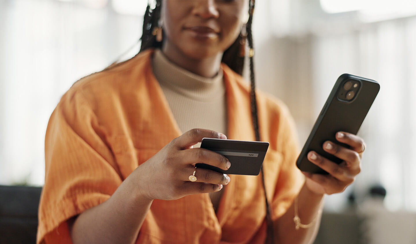 Person using phone while holding a bank card